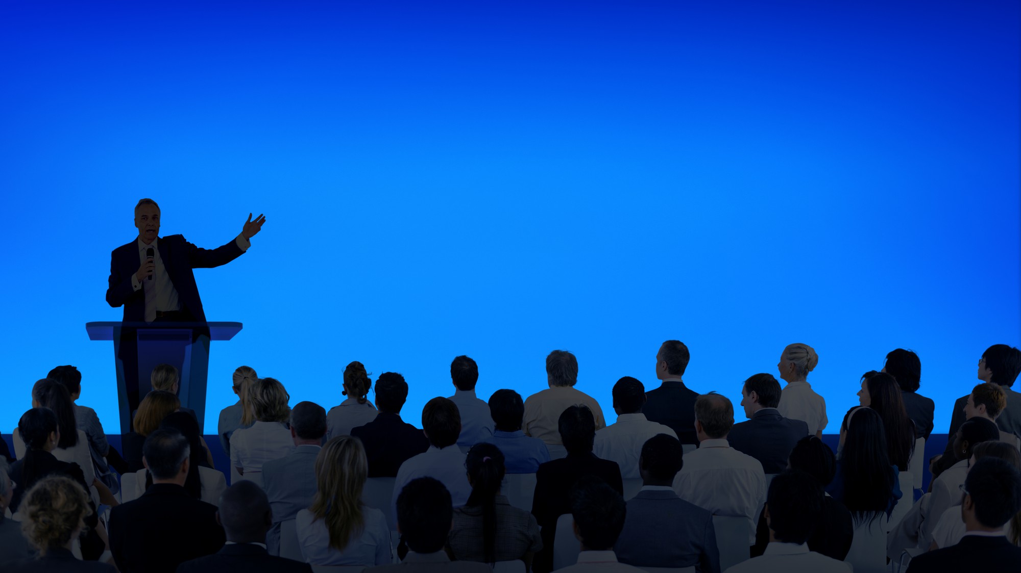 corporate-businessman-giving-presentation-large-audience
