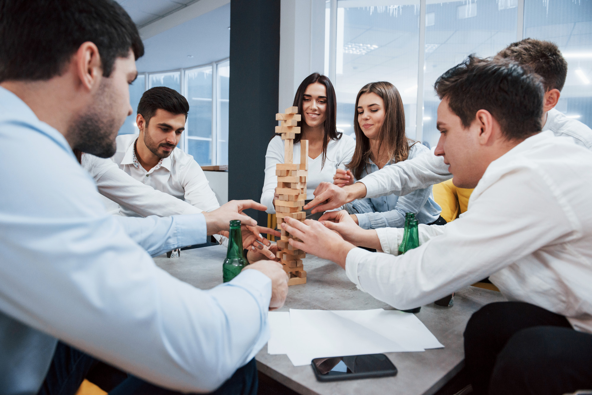 it-s-almost-fall-celebrating-successful-deal-young-office-workers-sitting-near-table-with-alcohol