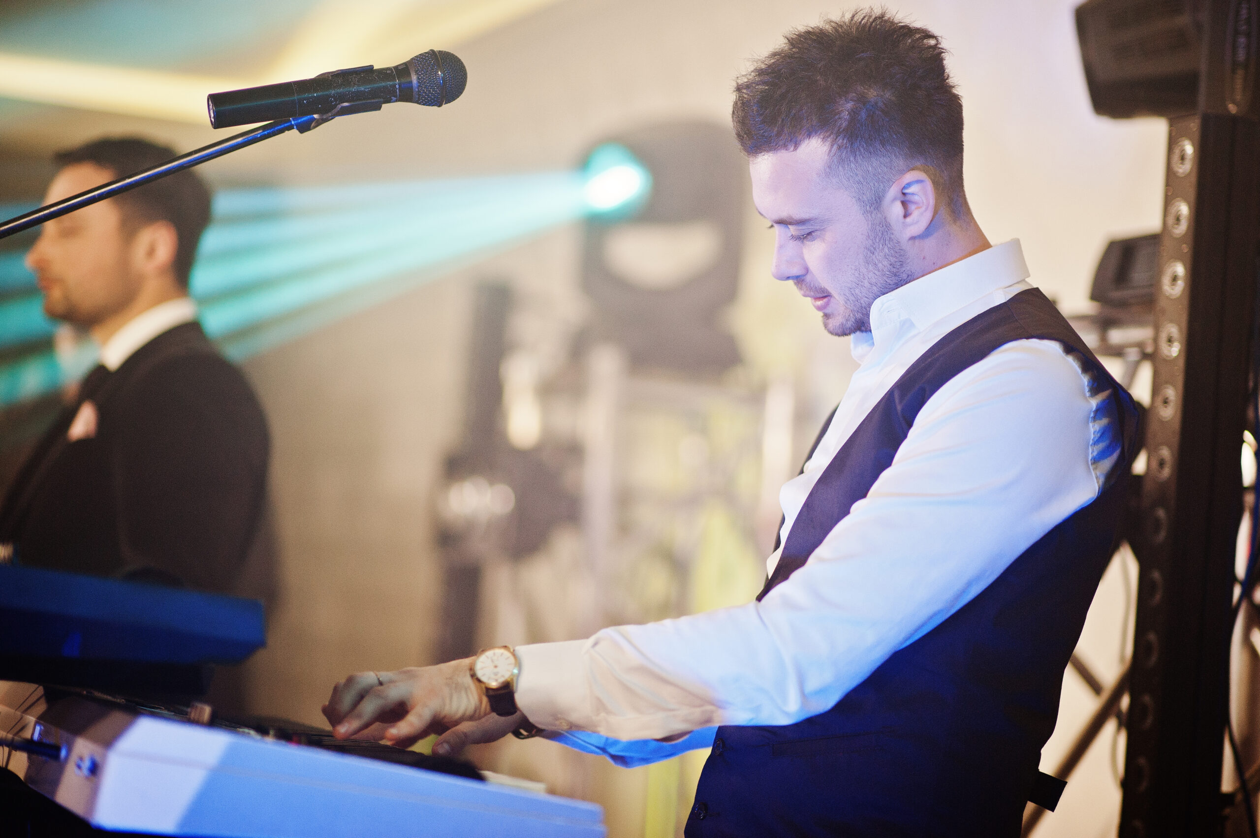 Musicial music live band performing on a stage with different lights. Keyboardist play.