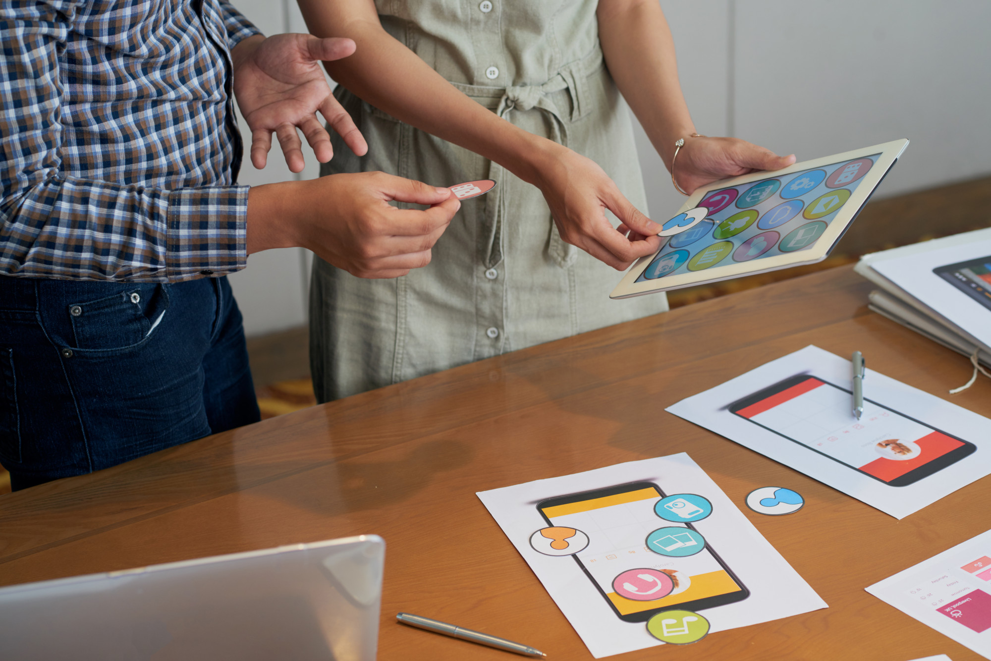 unrecognizable-colleagues-looking-tablet-trying-different-icons